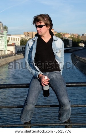 Cool dude with a bottle against the river