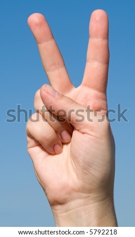Victory sign with blue sky behind