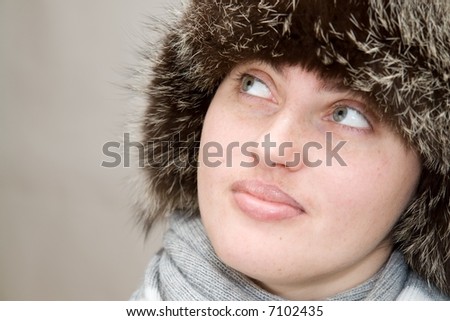 Warming Up. Young woman wearing a wool scarf and knit hat. Winter time.