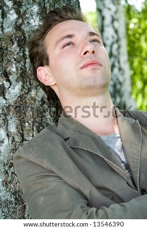 Nostalgia. Pensive sad man against a birchwood