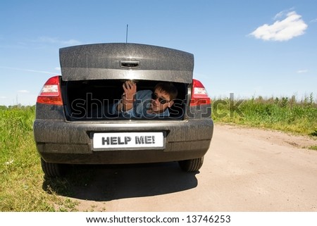 Help me! Man in the car luggage carrier.