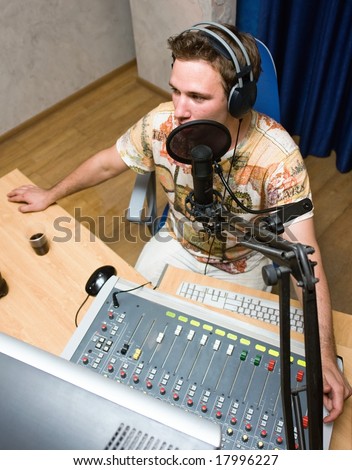 Radio DJ.  Young man with microphone and big headphone.