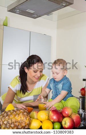 Mother and child making fresh orange juice -healthy life