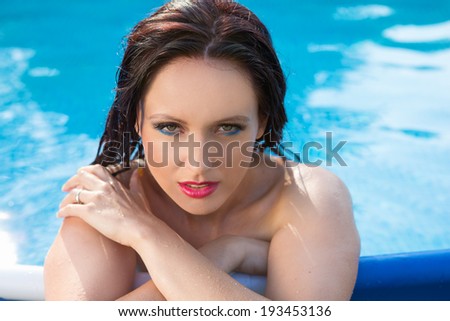 Bathing beautiful woman posing in her bikini in the swimming-pool