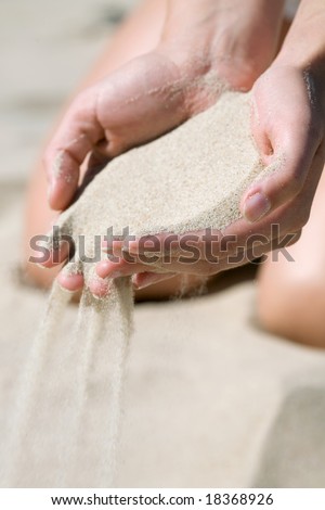 Falling sand in woman hands