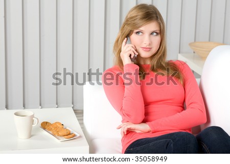 Casual woman at home on the couch using cellphone