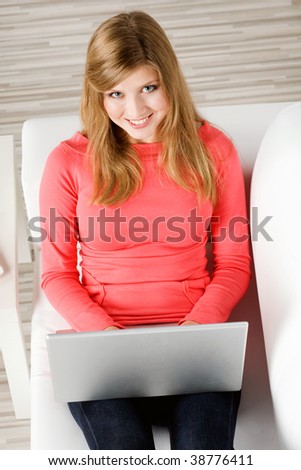 young woman sitting in the couch with  laptop
