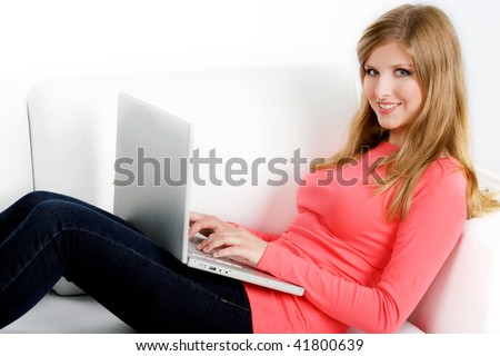 Smiling woman with laptop sitting on couch