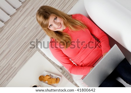 young woman sitting on couch with laptop
