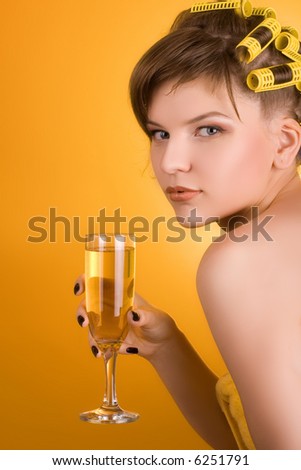 girl with hair-rollers holding a glass of wine