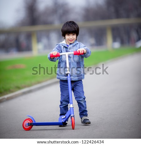 a boy with a new scooter on open air