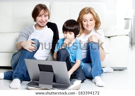 Young parents with children, on laptop computer