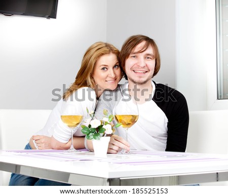 young woman in home having meal and wine with her husband