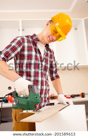worker works jigsaw in the interior of a new apartment