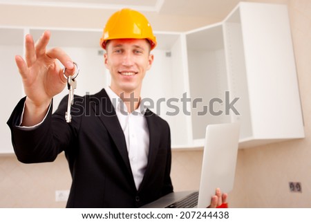 civil engineer with a laptop gives the keys to the apartment