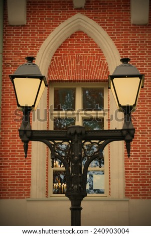 Old-time cast-iron torch on background of window of the old-time building, instagram image style
