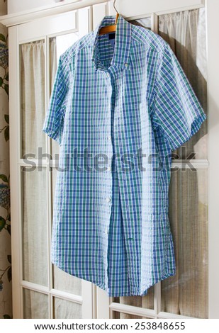cotton summer shirt on a hanger on the door wardrobes