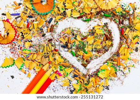heart, three pencils and colored wooden shavings on the white background