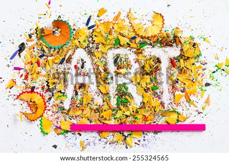 art word on the background of colored pencil shavings and pencil pink