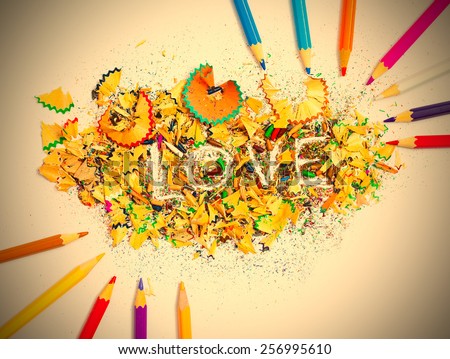 word Love on the background of colored pencil shavings. instagram image retro style