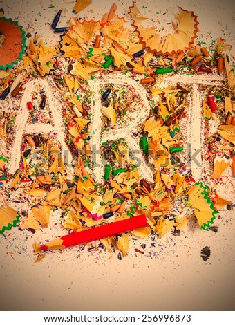 art word on the background of colored pencil shavings on the white. instagram image retro style