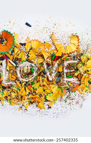 The word Love on the background of colored pencil shavings, vertical