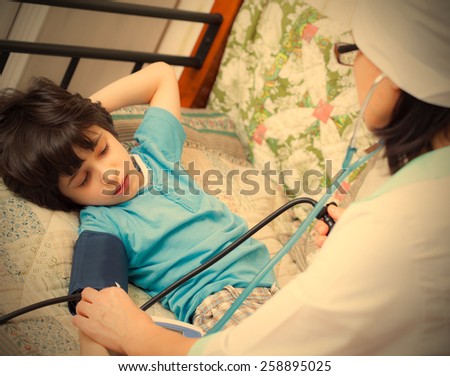 children\'s family doctor measures the blood pressure of boy. instagram image retro style