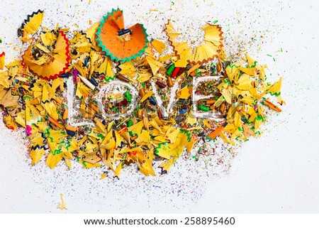 word Love over a shavings of colored pencils for drawing
