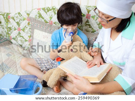doctor pediatrician spends boy inhalation session and reads him a book