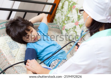 children's family doctor measures the blood pressure of boy