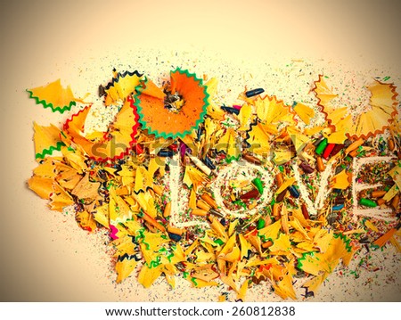 word Love on the white background of colored pencils shavings, still life. instagram image retro style