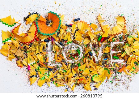 word Love on the white background of colored pencil shavings, still life. instagram image retro style