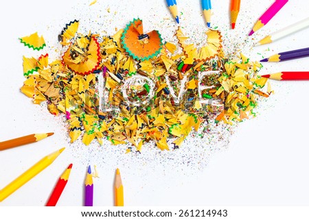 word Love on the white background of colored pencil shavings, still life