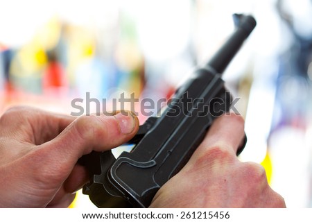 Luger automatic pistol in a human hand, shallow depth of field. close-up