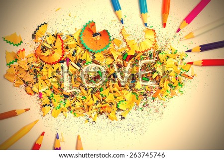 The word LOVE on the background from colored pencil shavings. instagram image retro style