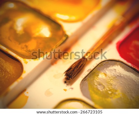 old brush and palette of paints. Shallow depth of field. instagram image retro style