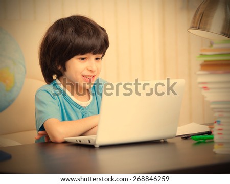 smiling boy looking at a computer monitor, distance learning. instagram image retro style