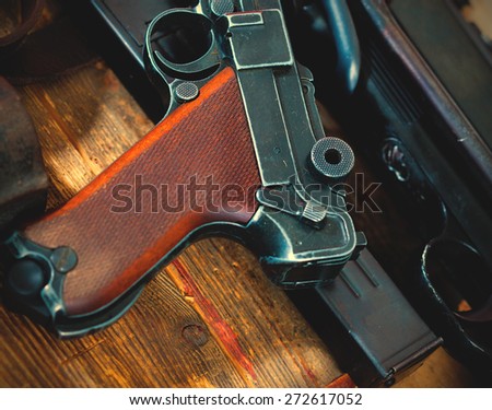 Luger Parabellum pistol and submachine gun MP 38 in gunsmith on table in a gunsmith. instagram image retro style