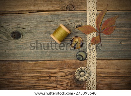 still life with lace ribbon, vintage buttons, spools of thread and dry Â on the surface of an old wooden table. instagram image retro style