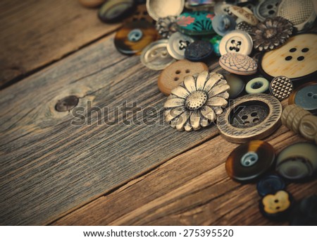 buttons in large numbers scattered on aged wooden boards of old desk. Copy space. instagram image retro style