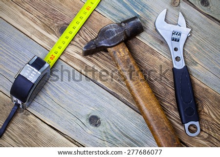 still life with working tools: a hammer, wrench and tape measure