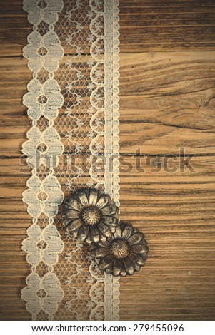 vintage button and lace tape on old wooden surface. instagram image filter retro style