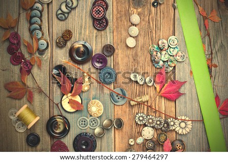 vintage buttons, reel with thread, herbarium and green tape, still life on tailor table. instagram image filter retro style