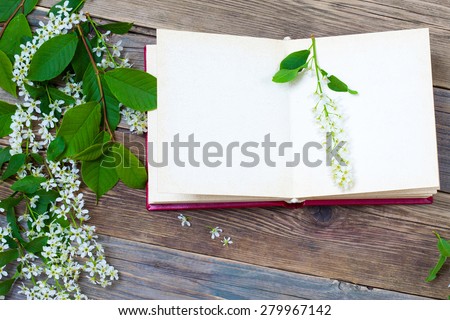 open book with bird-cherry branches on old surface boards