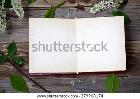 album with open pages and blossom bird-cherry  on aged boards of antique table