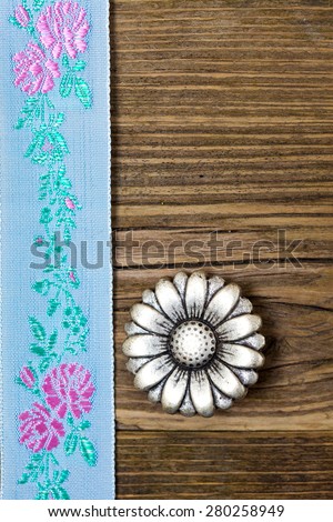 still life, vintage aqua color band with embroidered ornaments and old button flower