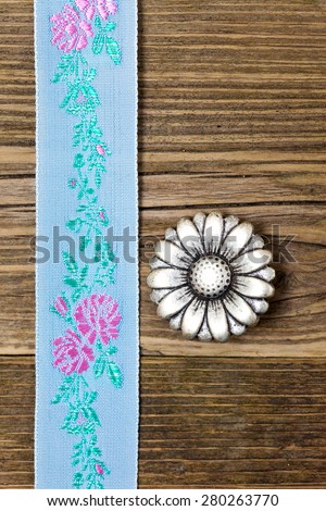 still life, vintage aqua color tape with embroidered ornaments and old button flower