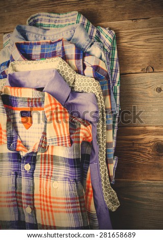bright shirts in a pile on a wooden shelf. instagram image filter retro style
