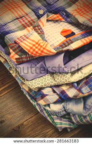 bright shirts in a pile on a wooden shelf. instagram image filter retro style