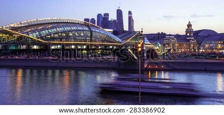 Night cityscape Moscow city with bridge, river and motion boat. Long exposure